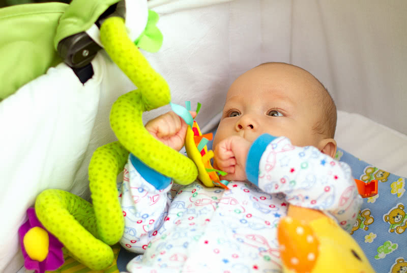 Vauva leikkii lelulla